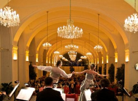 シェーンブルン宮殿オランジェリー - オランジェリーのクラシックコンサート会場 シェーンブルン宮殿オランジェリー - オランジェリーのクラシックコンサート会場。前面にシェーンブルン宮殿劇場管弦楽団の演奏家たち、中央にペアダンサー、背景に観客
