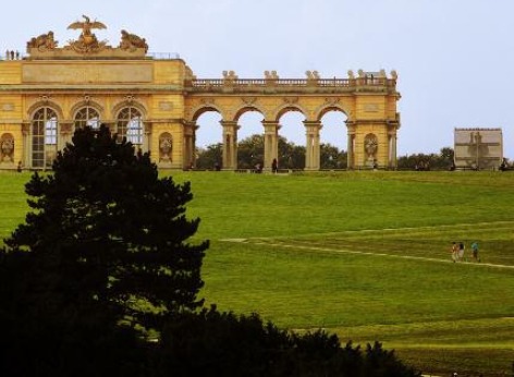 シェーンブルン宮殿の有名なグロリエッテ シェーンブルン宮殿の有名なグロリエッテ、建物左部分と中央部分やその手前の小さな丘に数名の観光客が向かっているのが見えます